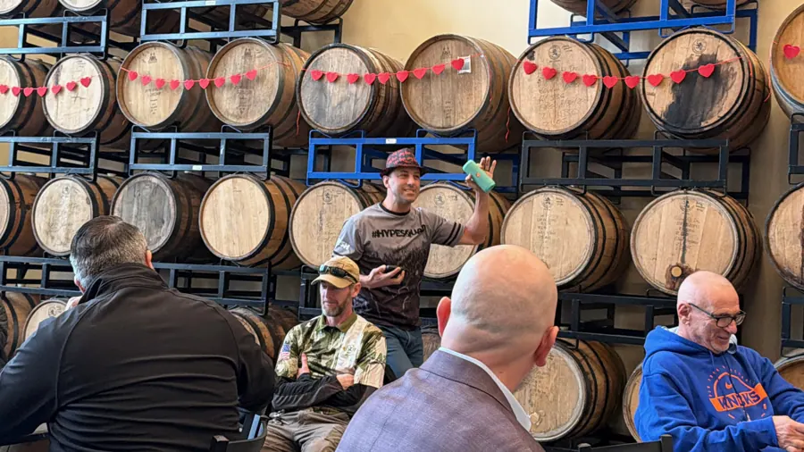 Members listening to a presentation among the barrels at Icarus